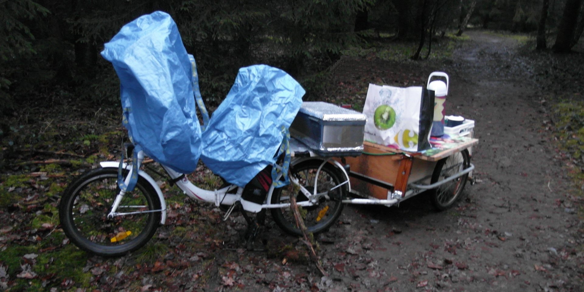 Fahrad mit Anhänger, beladen mit Thermoskannen und anderen Dingen