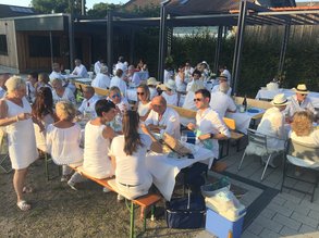 in weiß gekleidete Menschen sitzen an Tischen