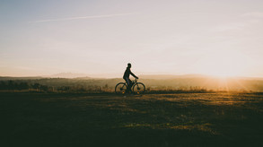 Radfahrer vor Sonnenuntergang radelnd 